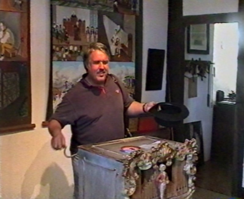 Тифлокомментарий к фото: один из посетителей музея музыкальных аппаратов З. Венделя и старинная шарманка.