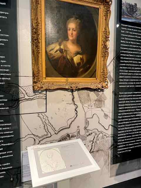 На цветной фотографии в зале постоянной экспозиции Большого дворца портер Екатерины Великой и тактильный макет портрета. 