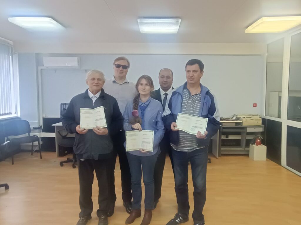 Общее фото выпускников программы «Информационные технологии (невизуальное использование сенсорных коммуникационных устройств для инвалидов по зрению») в компьютерном классе. На первом плане 3 выпускника программы, позади них преподаватель Института- Гладышев В.В. и заместитель генерального директора по информационным технологиям Арнапольский Е.Е.