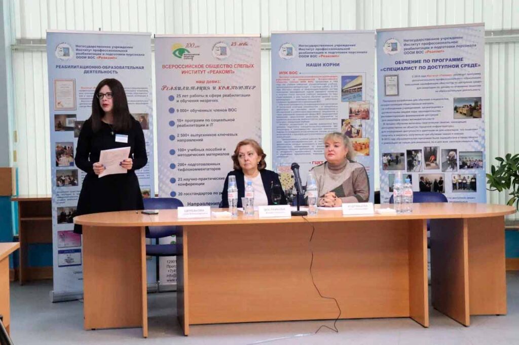 Тифлокомментарий к первой фотографии: Конференц-зал Института «Реакомп». Открытие конференции «Развитие тифлокомментирования в регионах России. Тифлокомментирование как правовая норма в обеспечении доступности информации для инвалидов по зрению». За президиумом начальник управления социального развития департамента социальной реабилитации АУ ВОС Вострикова М.Г., заместитель генерального директора по реабилитации и подготовке руководящих кадров Кудрявцева О.Е. и главный специалист по реабилитации и проектному менеджменту Щербакова М.А.