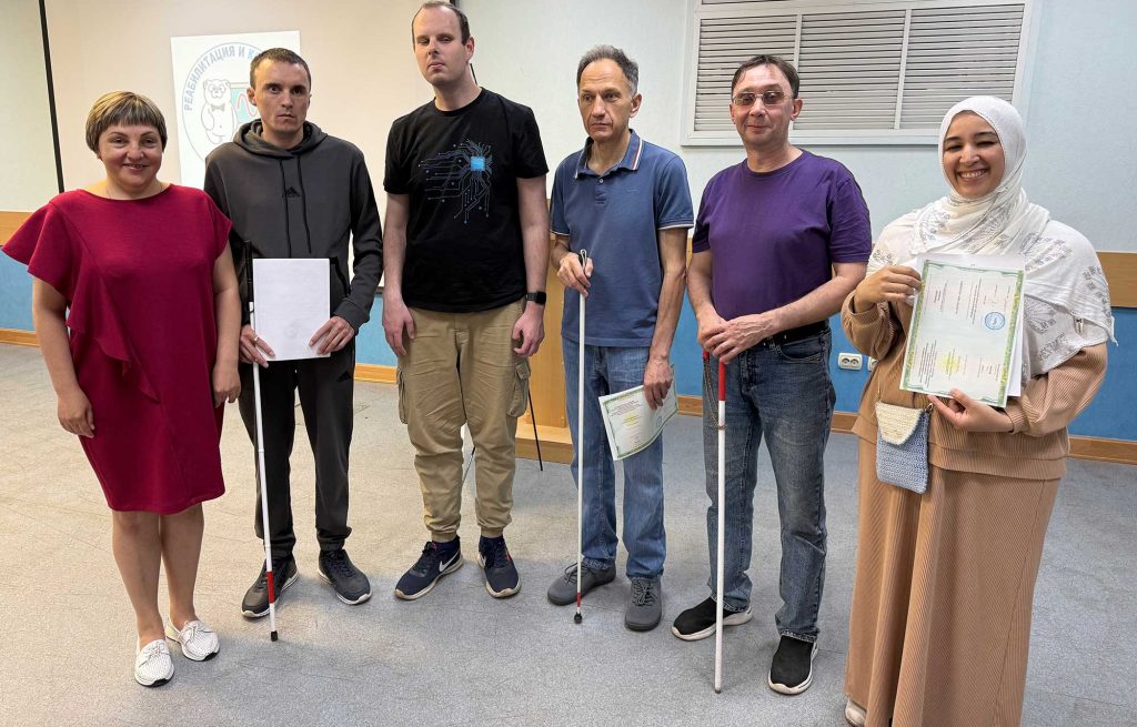 Тифлокомментарий к фотографии: Выпускники программы повышения квалификации «Информационные технологии» с преподавателем А. Д. Панфиловым в конференц‑зале Института.