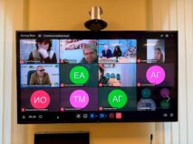 Тифлокомментарий к фотографии. Экран телемонитора. На нём отображены: президент ВОС В.В. Сипкин, сотрудники Института «Реакомп» и слушатели программы «Социальная реабилитация» - вновь избранные председатели и секретари МО ВОС.