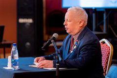 Тифлокомментарий к первой фотографии: Выступление С.Н. Ваньшина – автора российской концепции тифлокомментирования. Он сидит перед микрофоном. На его груди несколько наград, включая две медали премии Н.Островского.