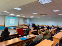 Тифлокомментарий к фотографии: конференц‑зал Института «Реакомп». В центре внимания — Сергей Николаевич и Ольга Павловна Ваньшины, которые ведут занятие для группы будущих тифлокомментаторов. В аудитории — 13 слушателей. Обстановка рабочая и продуктивная.