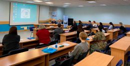 Тифлокомментарий к фотографии: конференц‑зал Института «Реакомп». В центре внимания — Сергей Николаевич и Ольга Павловна Ваньшины, которые ведут занятие для группы будущих тифлокомментаторов. В аудитории — 13 слушателей. Обстановка рабочая и продуктивная.